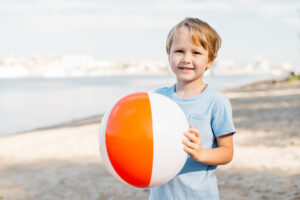smiling-boy-carrying-beach-ball smiling-boy-carrying-beach-ball